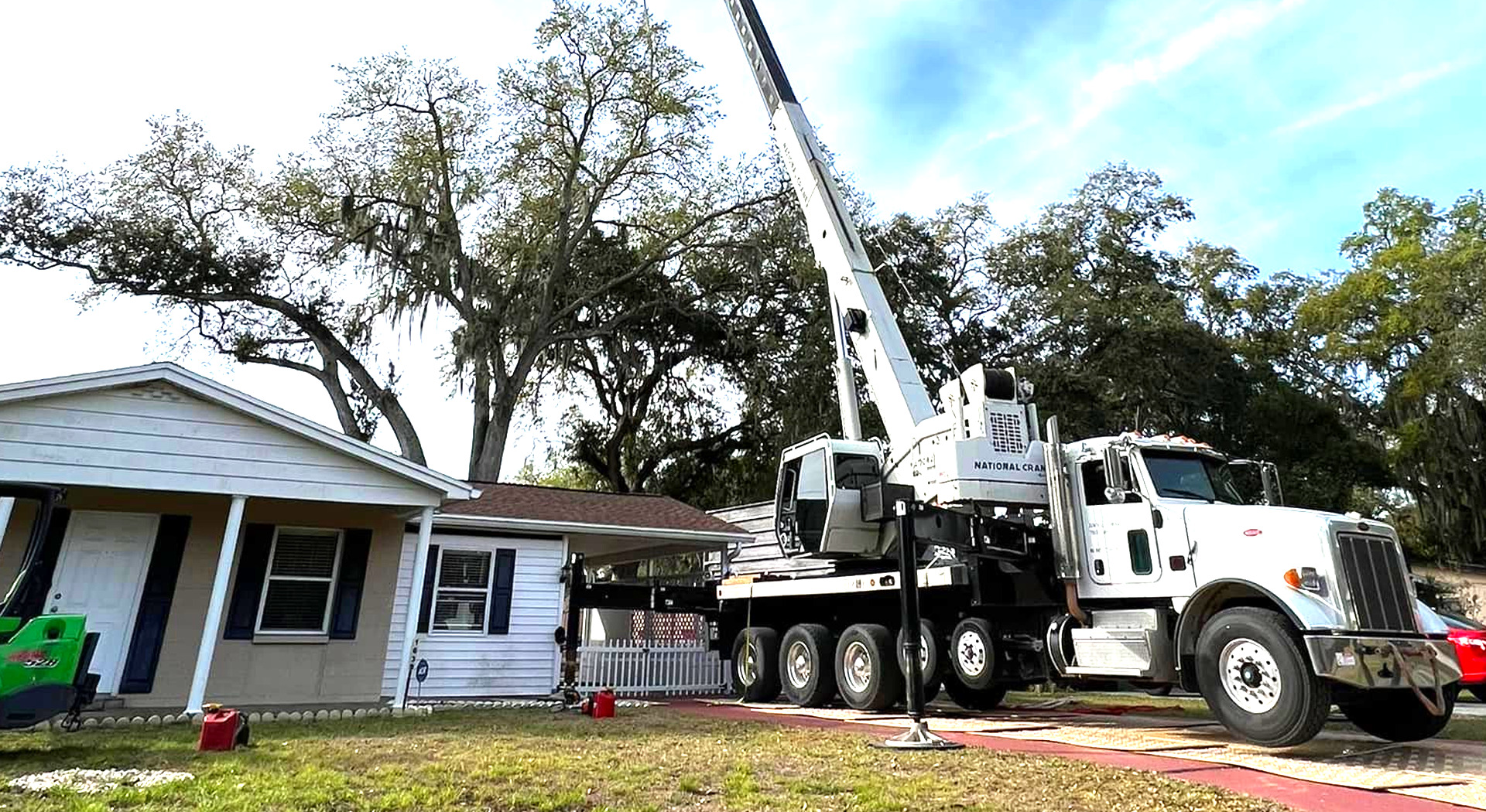 Central Florida Tree Care crane truck set up beside a house in Plant City, Florida
