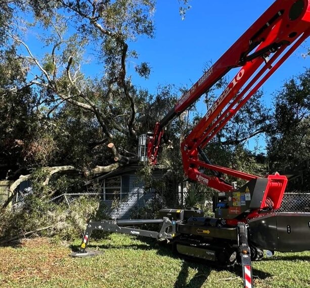 Spider lift positioned beside a home for tree access